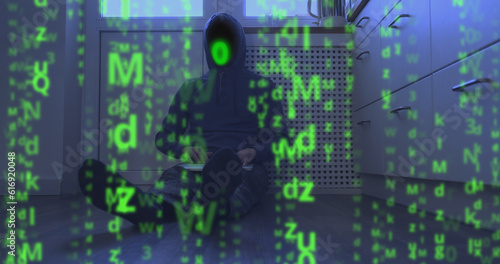 Matrix video effect, binary code instead of face of hooded programmer sitting on floor with laptop. Abstract, screen-filling green symbols. Concept of cyber security, end of system hacking, internet