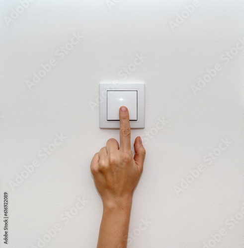 Female finger on light switch close-up. photo
