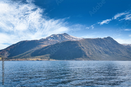 Fjord with mountains on horizon. Water glistens in the sun in Norway. Landscape