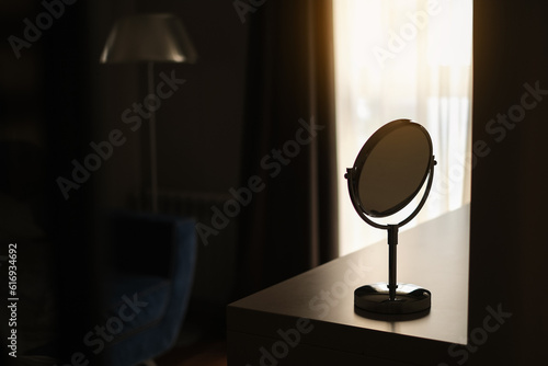 cosmetic makeup mirror on the table in the dark room close-up