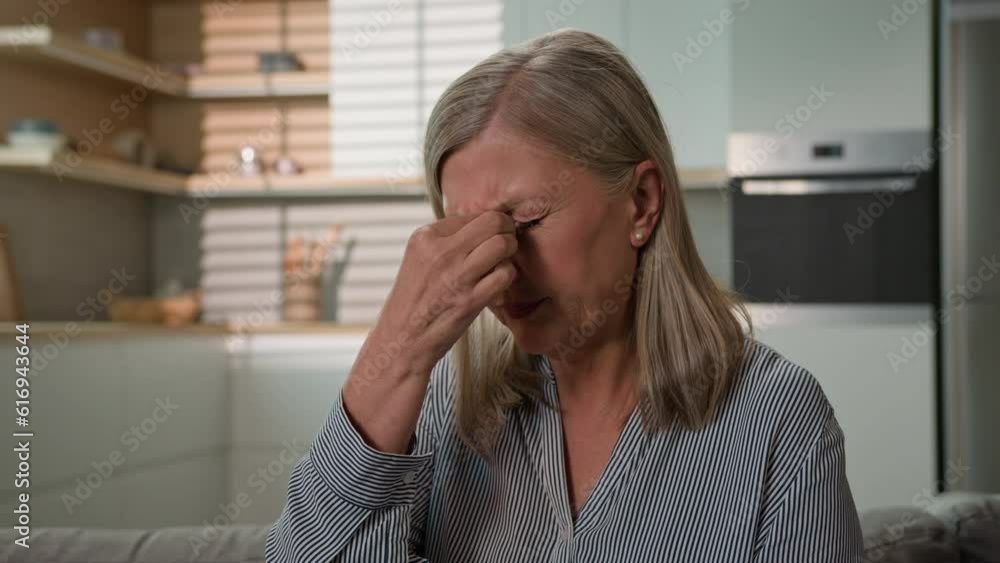 Tired elderly caucasian woman rub nose bridge massaging feel headache at home unwell mature lady female suffering pain experiencing migraine stress feeling fatigue suffer eye strain vision problem Tired elderly caucasian woman rub nose bridge massaging feel headache at home unwell mature lady female suffering pain experiencing migraine stress feeling fatigue suffer eye strain vision problem