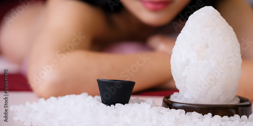 Candle with body therapy massage in the background. Health and body wellness concept. Skin relaxation and treatment. Sauna and regeneration. Healing salt lamp. Ai generative.