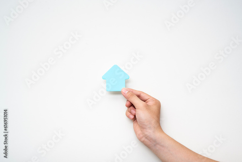 paper house on hand on white background, family house concept, family day care, real estate, housing and mortgage,foster home care or family day care, home minimal style.