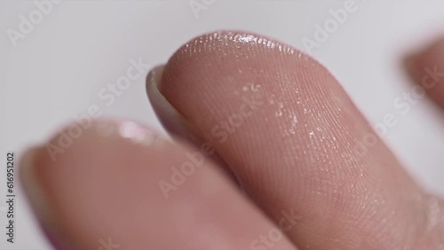 woman spraying antiseptic on her finger, close-up
