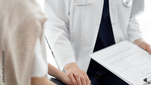 Doctor and child patient. The physician is holding clipboard and reassuring a boy. The concept of ideal health in medicine © rogerphoto