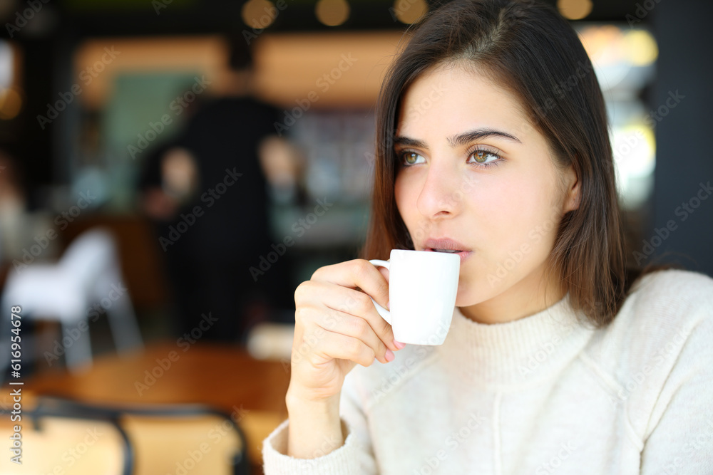 Serious woman drinking coffee in a bar alone Serious woman drinking coffee in a bar alone