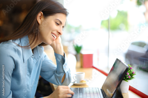 Happy woman in a coffee shop using tablet