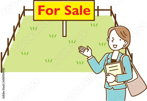 forsaleの看板が出ている分譲地を案内する住宅会社の女性