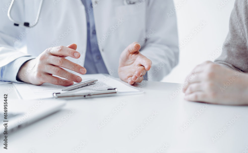 Doctor and patient discussing current health questions while sitting at the table in clinic office, only hands closeup. Medicine concept Doctor and patient discussing current health questions while sitting at the table in clinic office, only hands closeup. Medicine concept