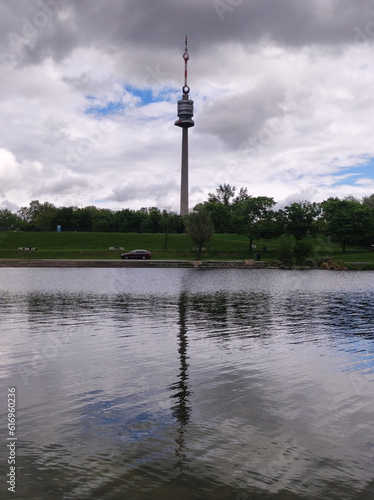 Photography Danube Tower in Vienna reflected in the Danube river with beautiful white swan