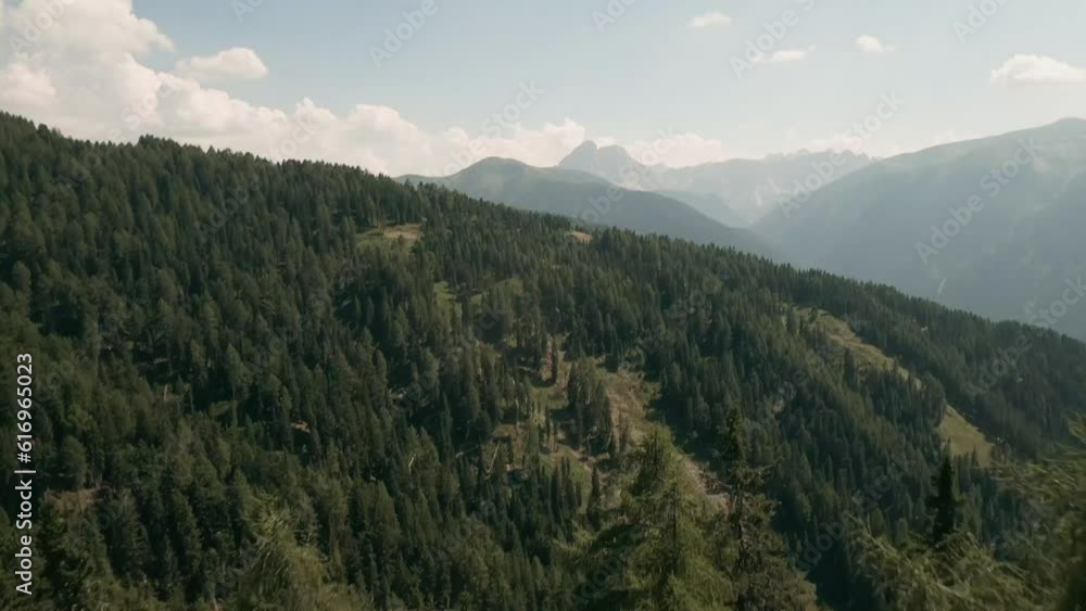 Fly through a forested landscape, unveiling a breathtaking view of the Dolomite mountains in this captivating FPV drone footage above Luzen village. LuPa Creative. Fly through a forested landscape, unveiling a breathtaking view of the Dolomite mountains in this captivating FPV drone footage above Luzen village. LuPa Creative.