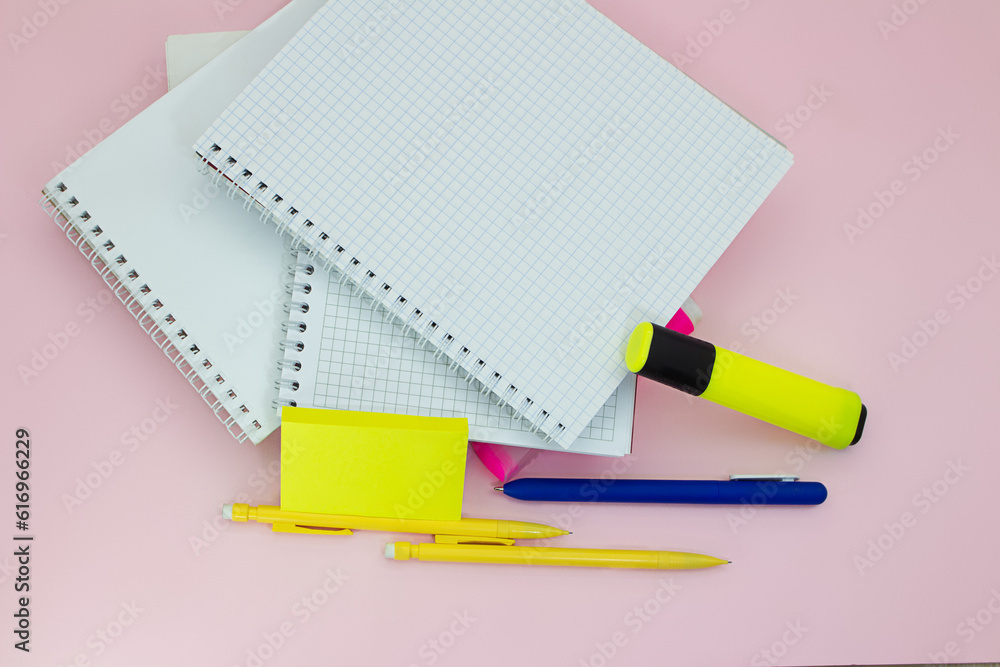 Notebooks with pens, markers and stickers on a pink background. Back to school business meeting. Copy space Notebooks with pens, markers and stickers on a pink background. Back to school business meeting. Copy space