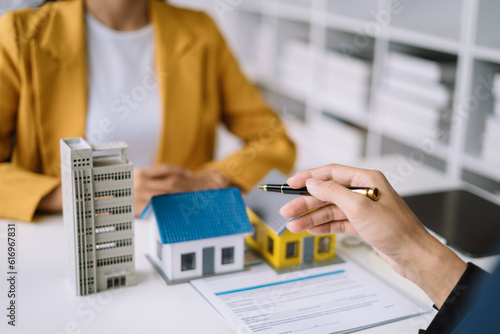 Buying a home or insurance deal, an insurance agent pointing a pen to those interested in renting a house, a contract, signing an Home buying agreement in office