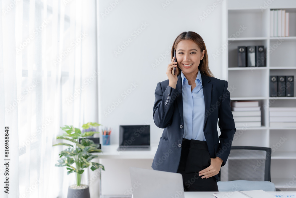 Asian businesswoman modern professional talking with client on the phone with a confident demeanor and effective communication skill. business, marketing, sale and communication project. Asian businesswoman modern professional talking with client on the phone with a confident demeanor and effective communication skill. business, marketing, sale and communication project.