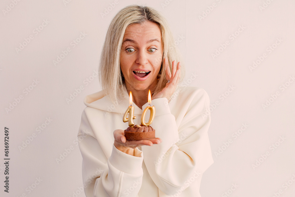 Portrait of happy middle aged woman holding birthday cake with lit candles Portrait of happy middle aged woman holding birthday cake with lit candles