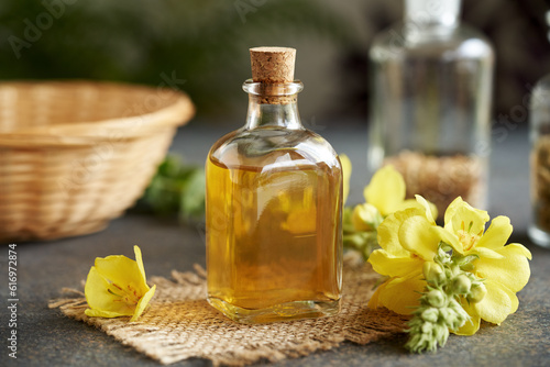 A bottle of herbal tincture with fresh mullein flowers