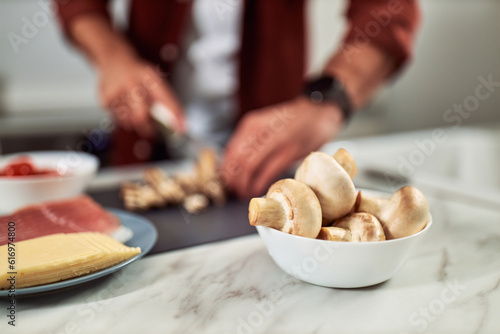 Fresh mushrooms in a vessel on the kitchen counter as one of the groceries for a delicious meal.