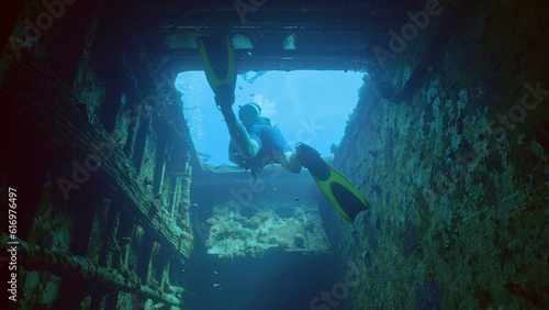 Scuba diver swims to exit inside cramped hold of ferry Salem Express shipwreck, Red sea, Safaga, Egypt