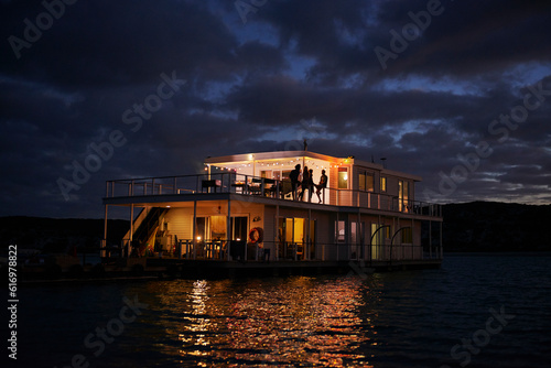 Summer houseboat illuminated on night ocean