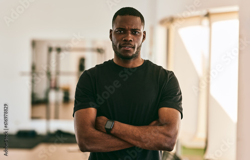 Confident African American male trainer standing with arms crossed