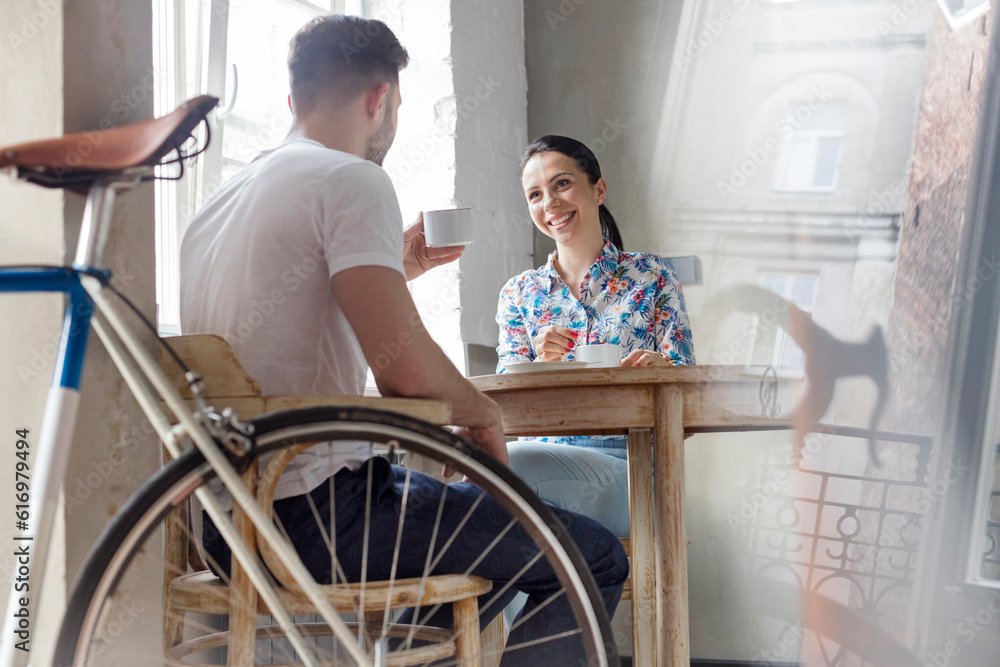 Couple drinking coffee and talking at table Couple drinking coffee and talking at table