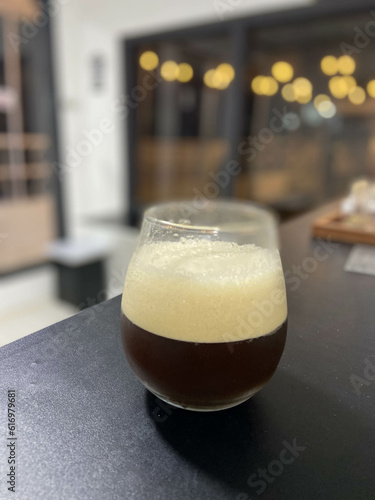 Ice shaken Americano with Foam on a Black Table Inside the Cafe