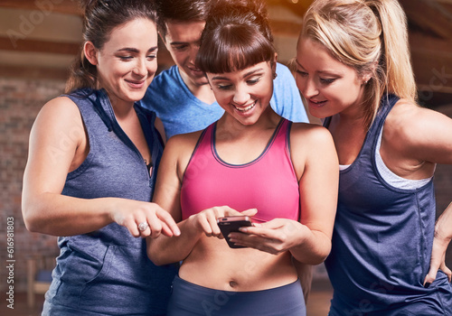 Young women and man in sports clothing texting with cell phone photo