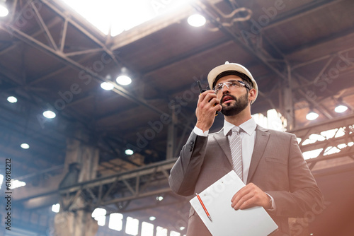 Manager with walkie-talkie in steel factory photo