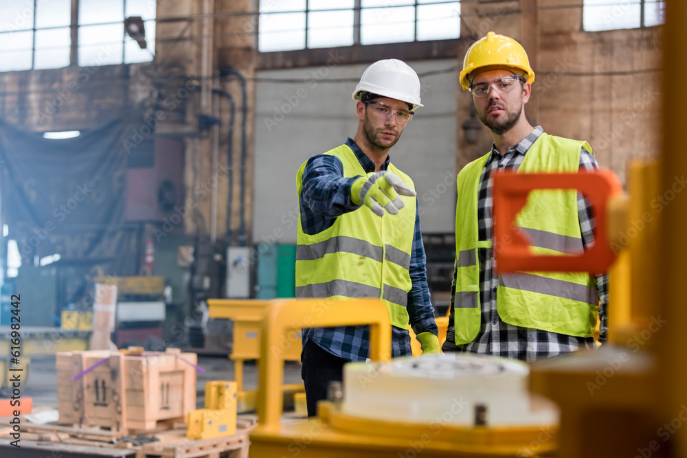Steel workers talking and pointing in factory Steel workers talking and pointing in factory