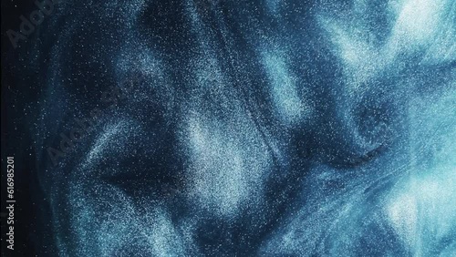 Glitter fluid. Sparkling wave. Ink water. Metallic blue color glowing shimmering grain particles texture smoke cloud motion on dark abstract background.