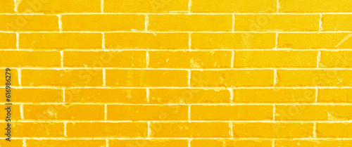 Orange and yellow brick wall, dark background for design, texture of a Orange and yellow painted brick wall as a background or wallpaper, grunge brick wall background.
