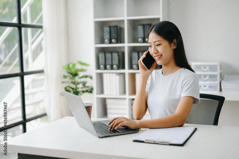 Happy asian business woman have the joy of talking on the smartphone, tablet and laptopon the office Happy asian business woman have the joy of talking on the smartphone, tablet and laptopon the office