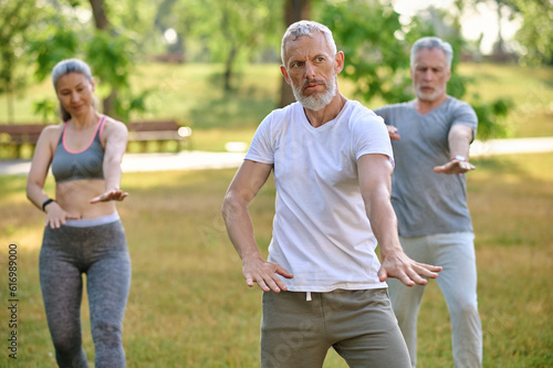 A group of people practicing qigong in a park
