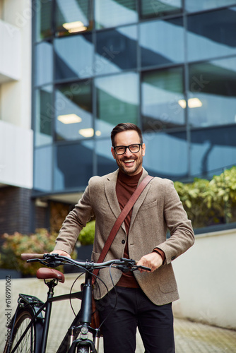 Portrait of a successful businessman with glasses on pushing a bicycle.