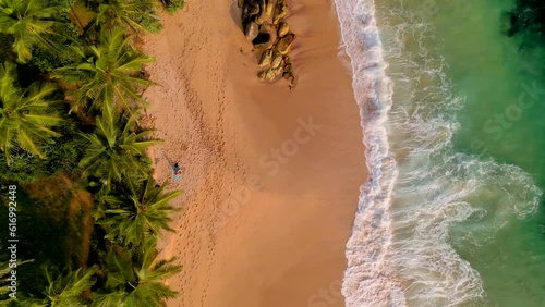 erial overview of huge waves crashing into the shore and rocks at a beach in Sri Lanka, overview shot showing the dynamic coastline of the turquoise waters of Tangalle, Sri Lanka. photo