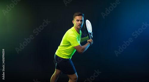 Padel Tennis Player with Racket in Hands. Paddle tenis, on a black background. Download in high resolution picture for magazine cover. © Mike Orlov