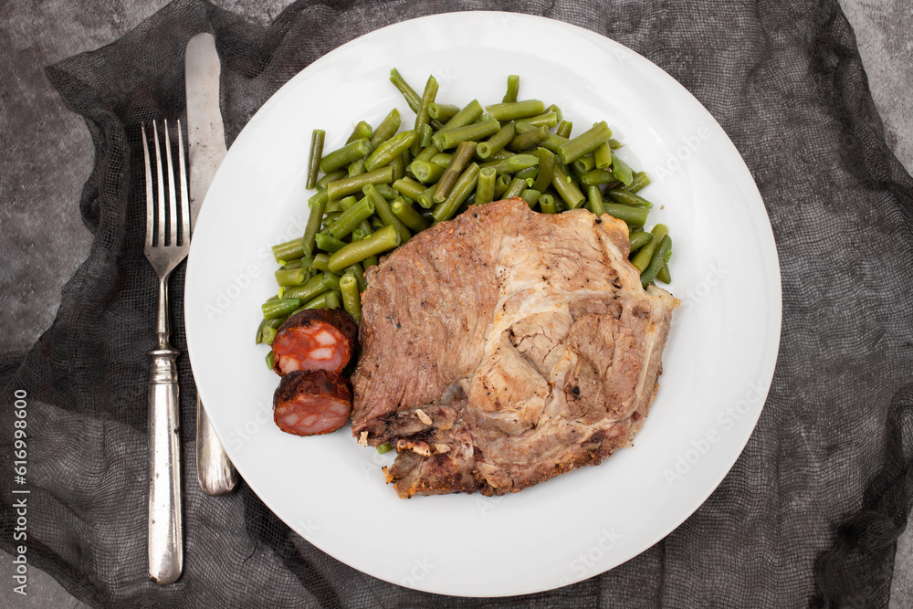 Green beans with meat and smoked sausages on plate Green beans with meat and smoked sausages on plate
