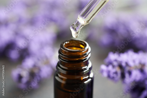 Φωτογραφία Dropping lavender essential oil into a brown glass bottle