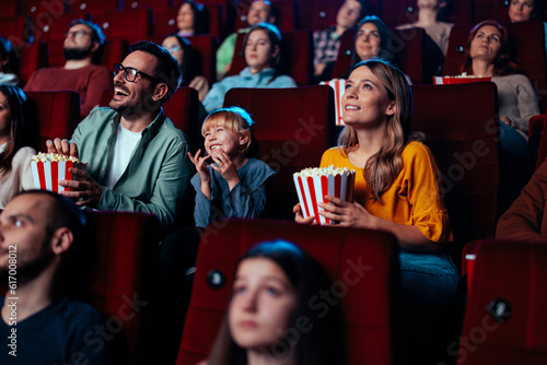 Young family watching movie in theater.