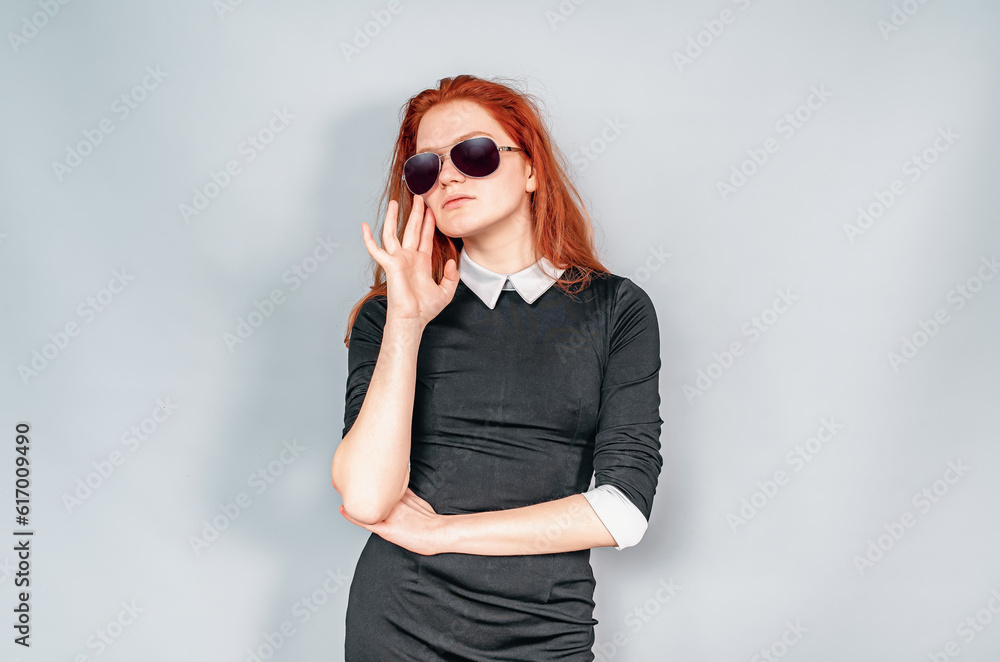 Fashionable woman in sunglasses. One hand on the waist, the other near the hair. Fashionable woman in sunglasses. One hand on the waist, the other near the hair.