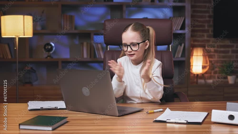 Little business executive dressed in formal clothes and glasses congratulating colleagues for teamwork success during online video meeting. Charming girl demonstrating gestures of great job. Little business executive dressed in formal clothes and glasses congratulating colleagues for teamwork success during online video meeting. Charming girl demonstrating gestures of great job.