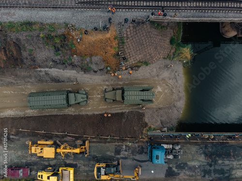 Pontoon bridge of the Ukrainian army. Installation of a temporary crossing near the destroyed bridge. Soldiers collect pontoon ferry. Top view from a drone. Nikopol, UKRAINE – May 26, 2020 © Denis Chubchenko