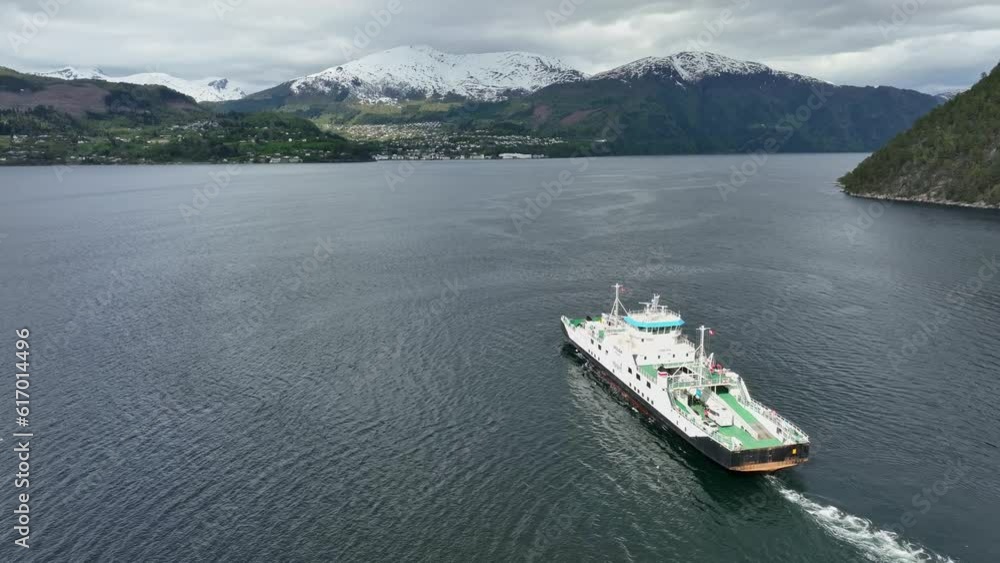 Ferry to Stranda in More and Romsdal Norway - Ferry named Volda is underway with Stranda town seen in background below snow capped mountain Ferry to Stranda in More and Romsdal Norway - Ferry named Volda is underway with Stranda town seen in background below snow capped mountain