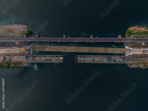 Pontoon bridge of the Ukrainian army. Installation of a temporary crossing near the destroyed bridge. Soldiers collect pontoon ferry. Top view from a drone. Nikopol, UKRAINE – May 26, 2020