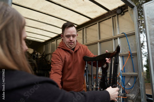 Worker with Down syndrome transporting furniture