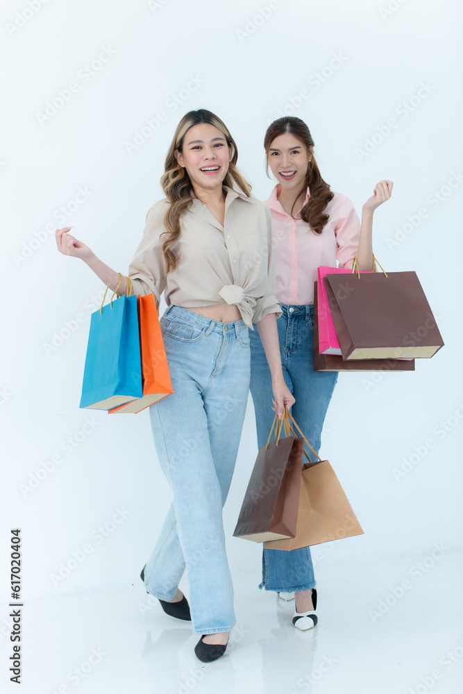 Two happy asian women holding shopping bags isolated on white background. Two happy asian women holding shopping bags isolated on white background.