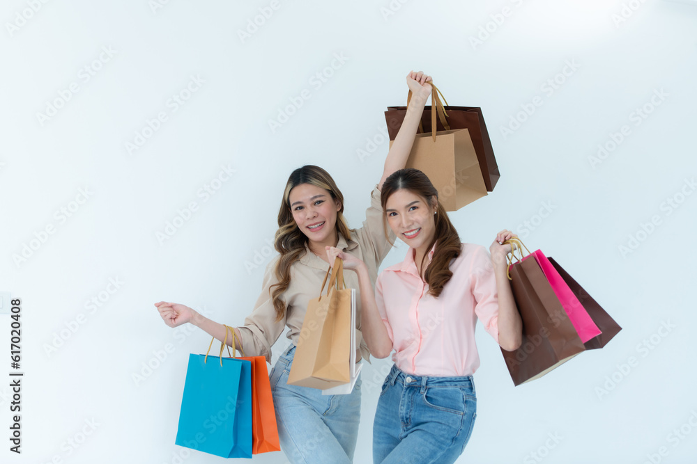 Two happy asian women holding shopping bags isolated on white background. Two happy asian women holding shopping bags isolated on white background.