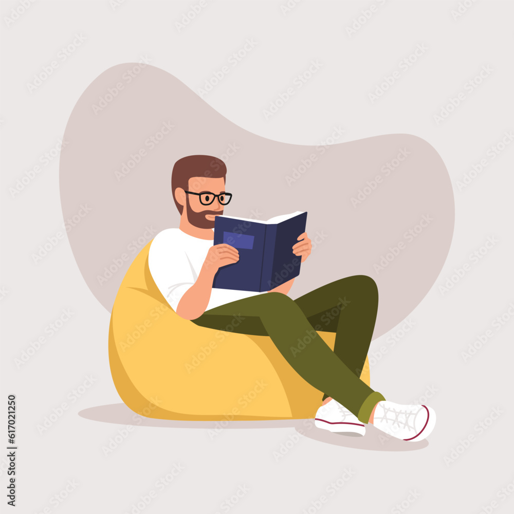 man sitting on a chair (ottoman) with a book