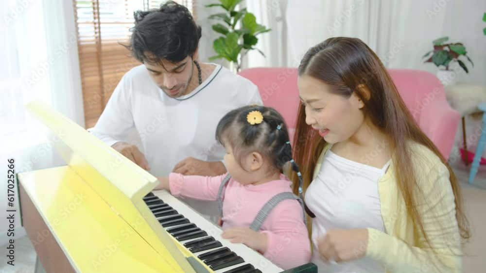 Asian mother and her daughter with a piano teacher playing piano together. Mom and teacher giving encourage her daughter playing the music, happiness in family at home. Asian mother and her daughter with a piano teacher playing piano together. Mom and teacher giving encourage her daughter playing the music, happiness in family at home.