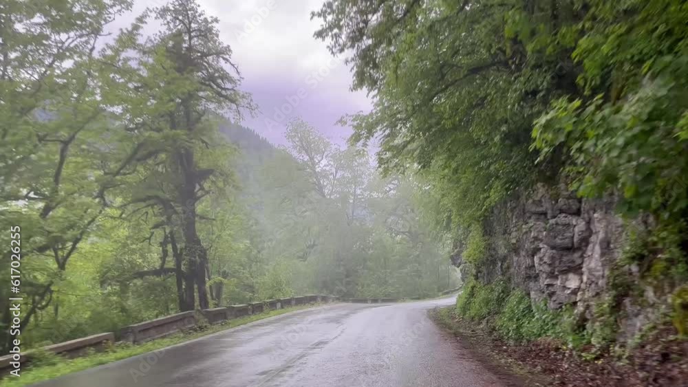 Wide point of view of driving in car. road trip with forest in Abkhasia, scenic beautiful road seen from the car window. Foggy mountains and forest landscape. Road trip journey Wide point of view of driving in car. road trip with forest in Abkhasia, scenic beautiful road seen from the car window. Foggy mountains and forest landscape. Road trip journey